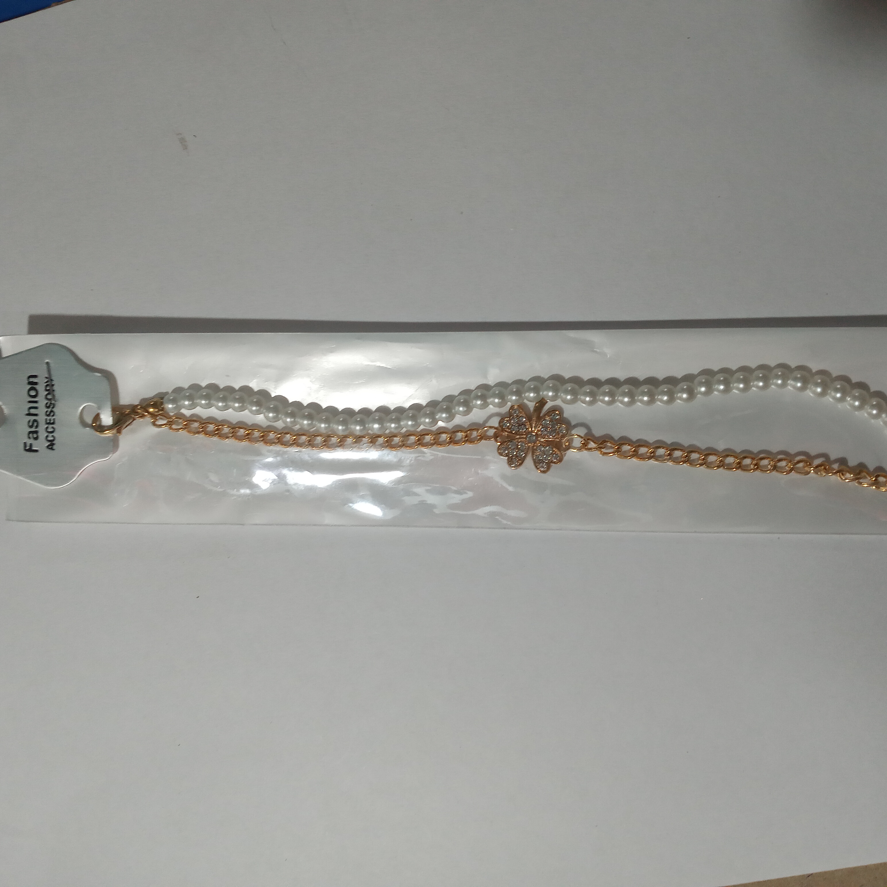 Pulsera dorada y blanca con flor con piedritas